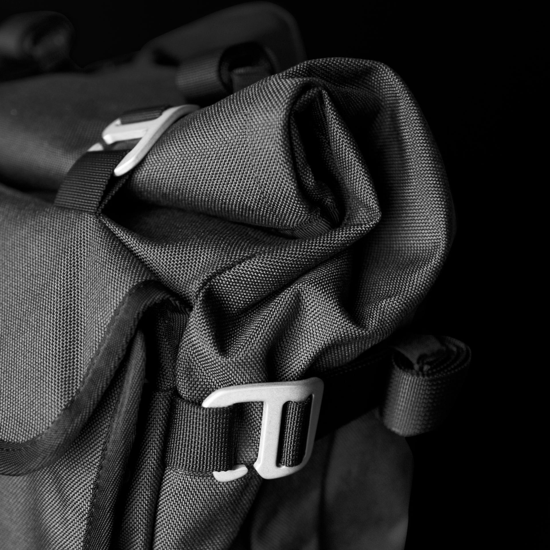 Rear harness of the Asphalt S on black, showing dual-density padded shoulder straps, sternum strap, load-lifters and a ventilated mesh back panel.